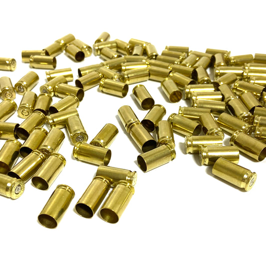 Pile of polished 9mm brass shells showing open mouths and spent primer dimples.
