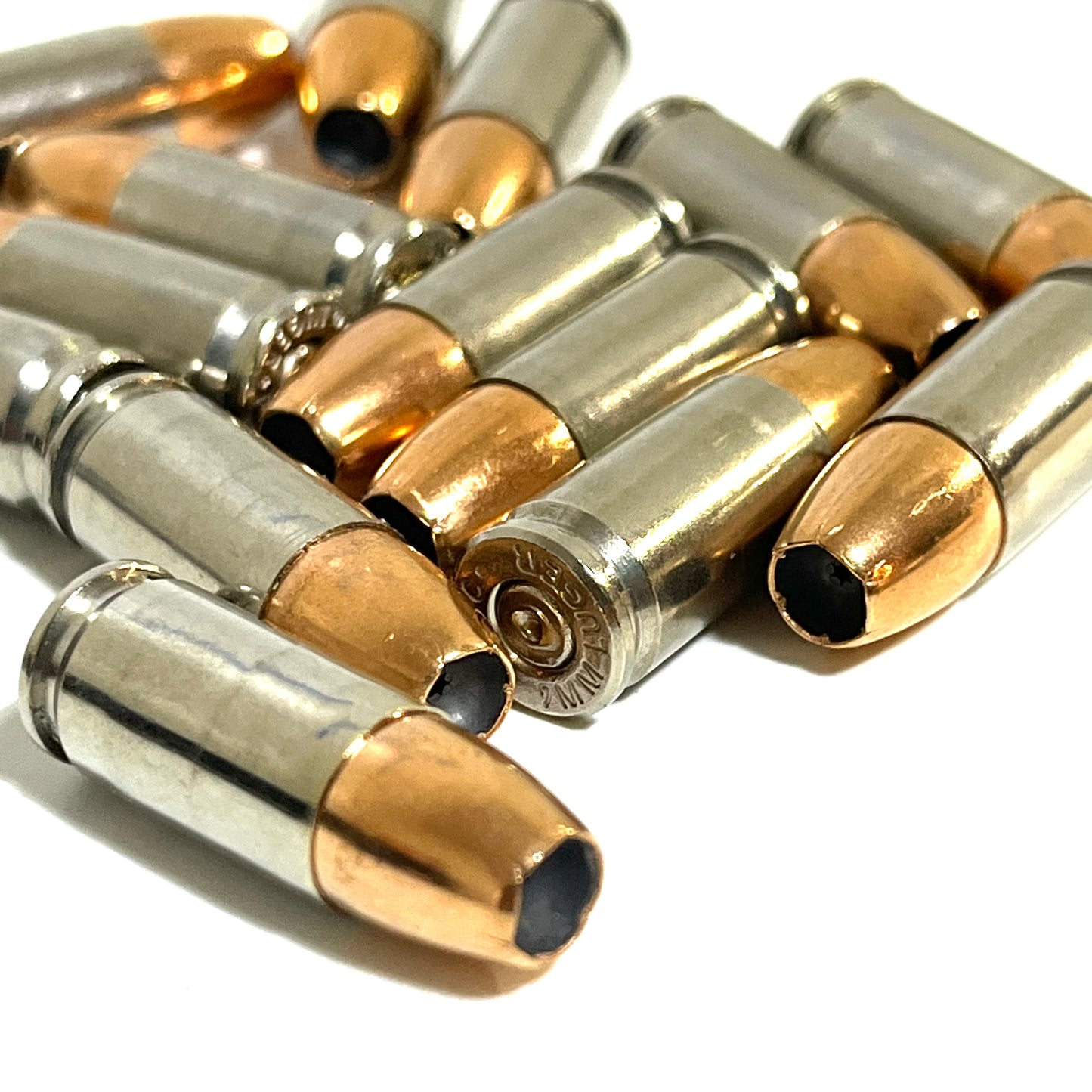 9MM dummy rounds laying down, showing head stamps and hollow point. Inert with no powder
