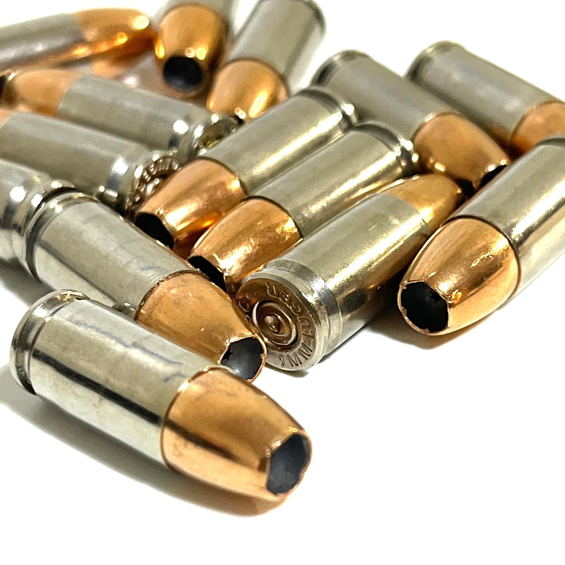9MM dummy rounds laying down, showing head stamps and hollow point. Inert with no powder