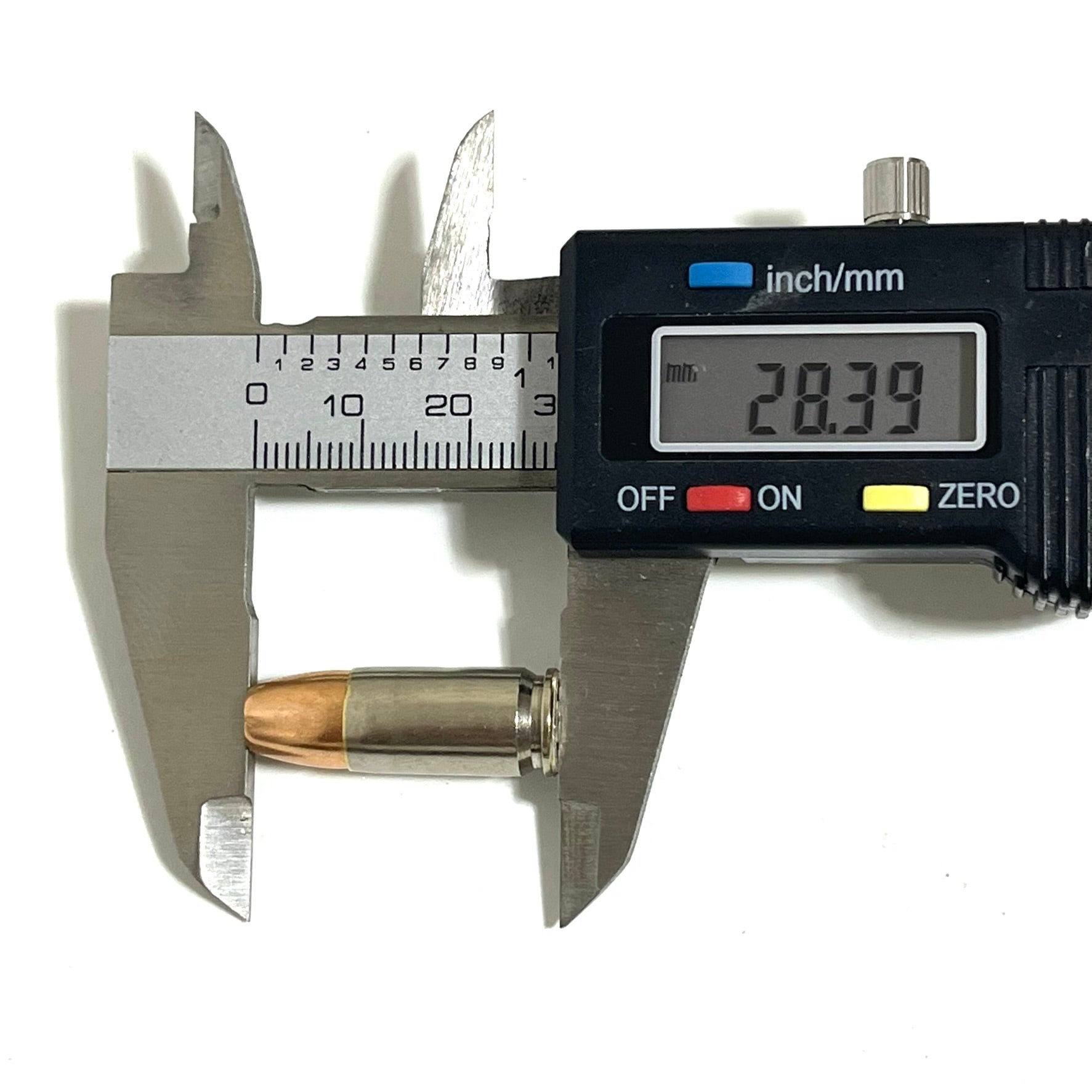    Digital caliper measuring the overall length of an inert 9MM Luger nickel dummy round at 28.39mm. Authentic once-fired brass casing with JHP bullet. Accurate scale reference for crafters and prop makers.
