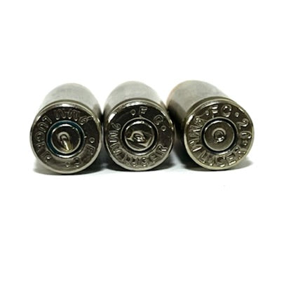 Bottom view of inert 9MM Luger nickel dummy round showing spent primer and authentic mixed headstamp. Once-fired recovered brass casing. Not live ammunition.

