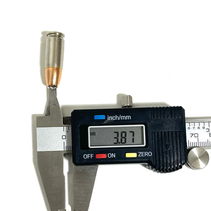 Digital caliper measuring the hole diameter of an inert 9MM Luger nickel dummy round at 3.87mm. Real once-fired brass casing with copper JHP bullet. Scale reference for jewelry and craft projects.

