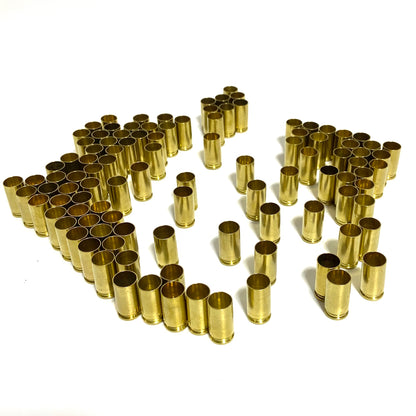 Orderly rows of polished 9mm brass shells showing open mouths.
