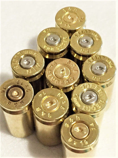 Polished 9mm brass shells showing headstamps and spent primer dimples.
