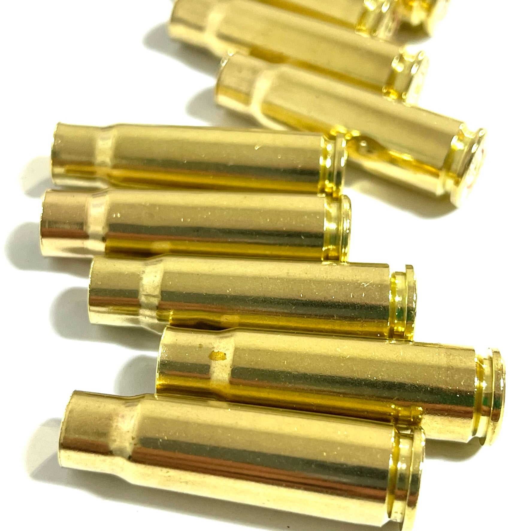 Several empty brass casings stacked at angles, side profiles and open mouths visible, on a white background.