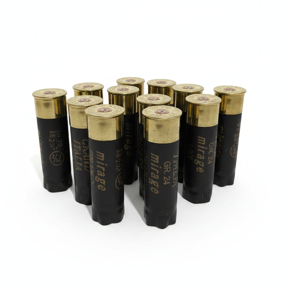 Group of black Mirage shotgun casings standing upright, showing brass headstamp caps on a wood surface.