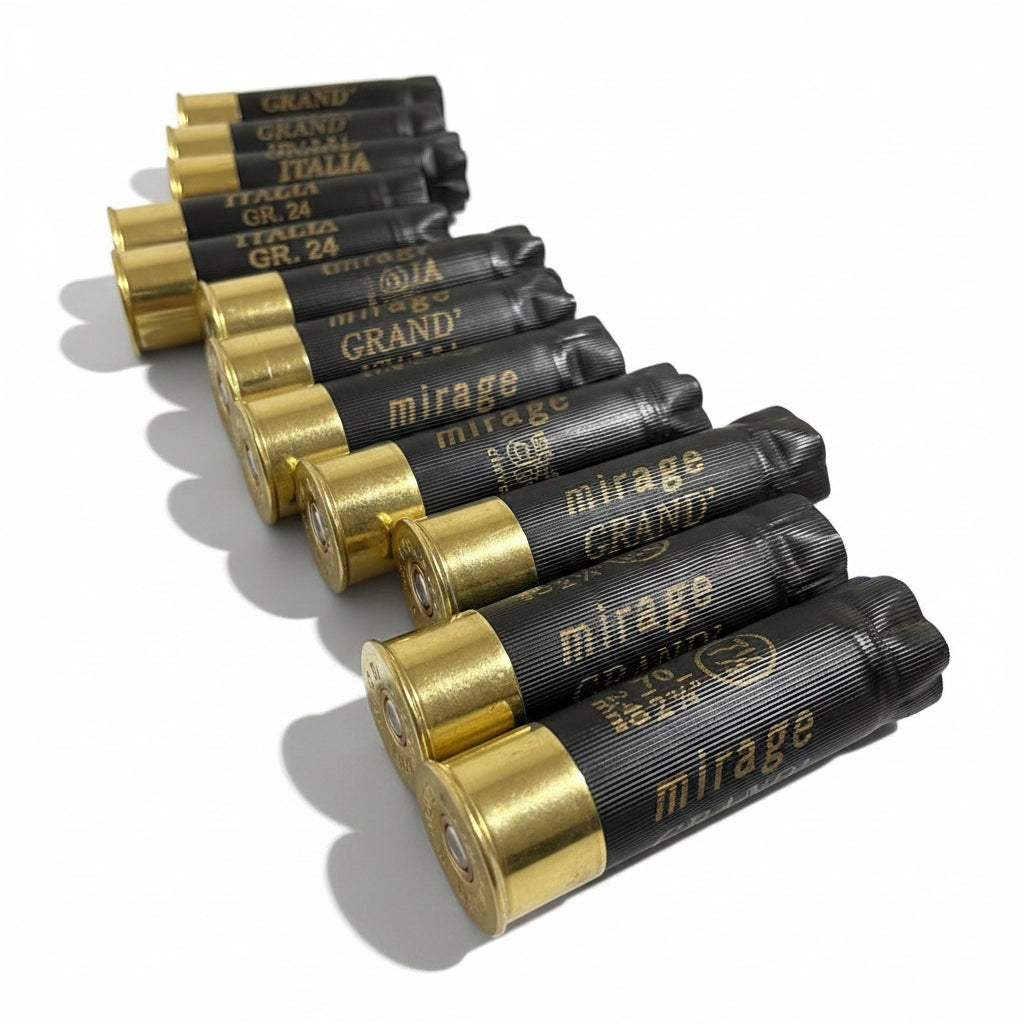 Row of black Mirage shotshells lying on their sides in a receding perspective on a wood surface.