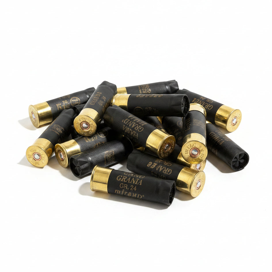 Black Grand Italia and Mirage shotshells arranged in a starburst pattern on a wood floor.