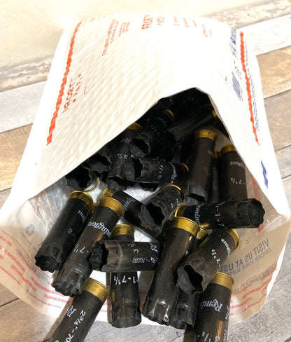Black 12 gauge empty shotgun shells with gold bases packed inside a padded shipping envelope
