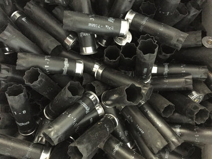 Five black empty Remington 12 gauge shotgun shells fanned out on a white surface with silver metal bases visible.