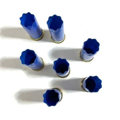 7 spent 12 gauge casings showing the 8 star-crimped open plastic tops.