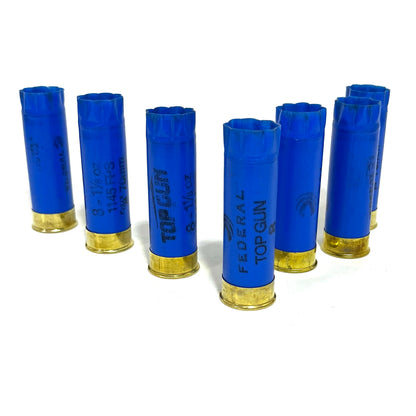 A row of blue 12ga Federal inert shotshells standing upright in a line.