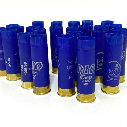Multiple blue Rio 12 gauge empty shotshells standing upright in organized rows on a white surface.