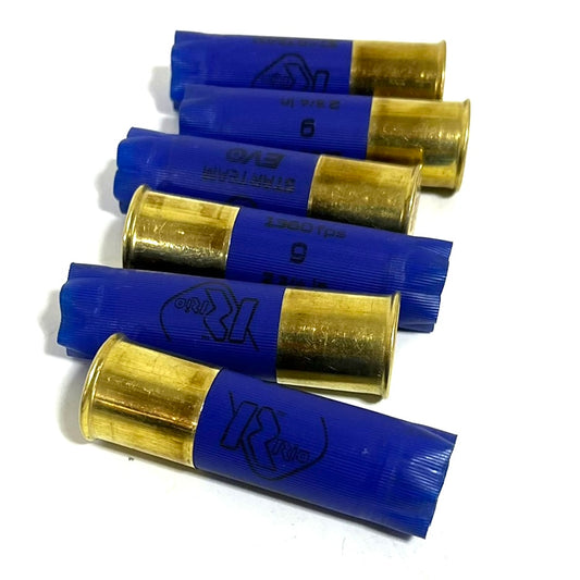 Five blue empty 12ga hulls lying horizontally in a stacked formation showing high brass bases.
