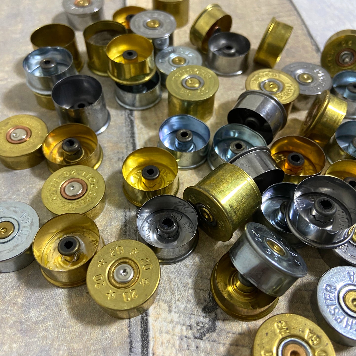 Collection of mixed metal 20 gauge fired shotshell end caps.