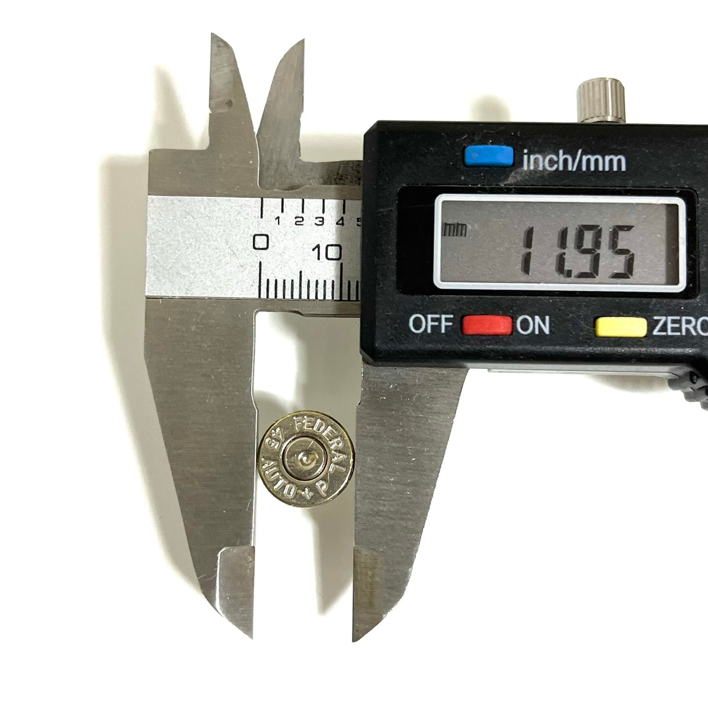 A digital caliper measuring the diameter of a brass bullet end cap slice showing 11.95 mm.