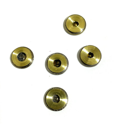 Five brass bullet slices bottom view  arranged in a cross design pattern on a solid white background.
