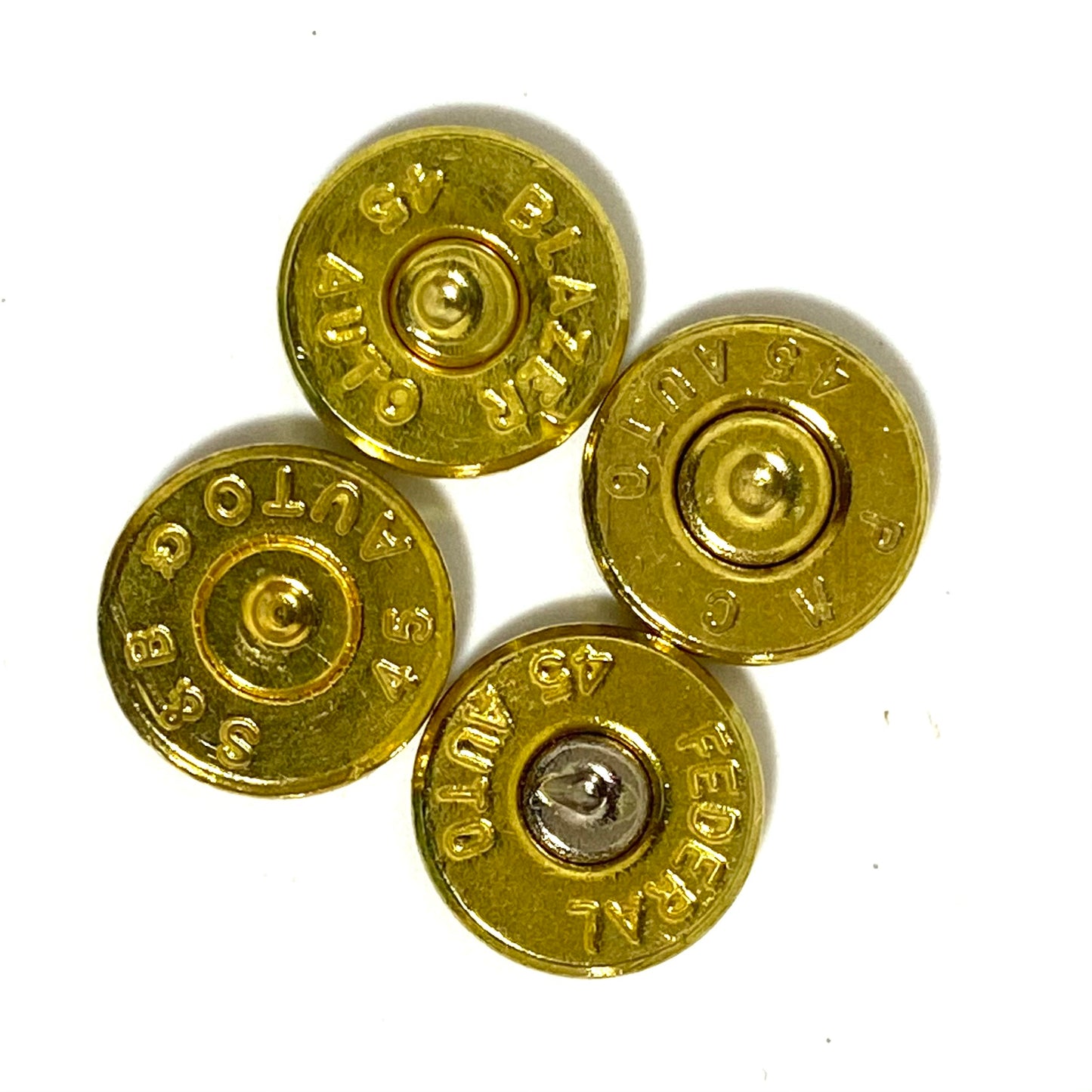 Four gold 45 ACP bullet slices clustered together, showing mixed headstamps including BLAZER and FEDERAL markings.