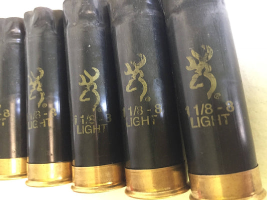 Five Browning 12-gauge black spent shotgun hulls standing upright with brass bases and gold logos.