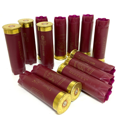Twelve burgundy Herter’s Target 12 gauge shotgun shells arranged in a cluster on a white background, showing gold star-crimped tops and bases