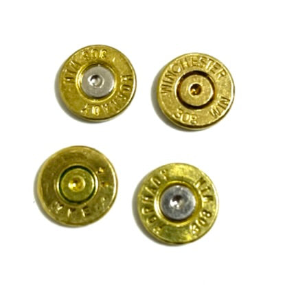 Four brass bullet slices with different headstamps and primer colors, arranged in a grid on white background