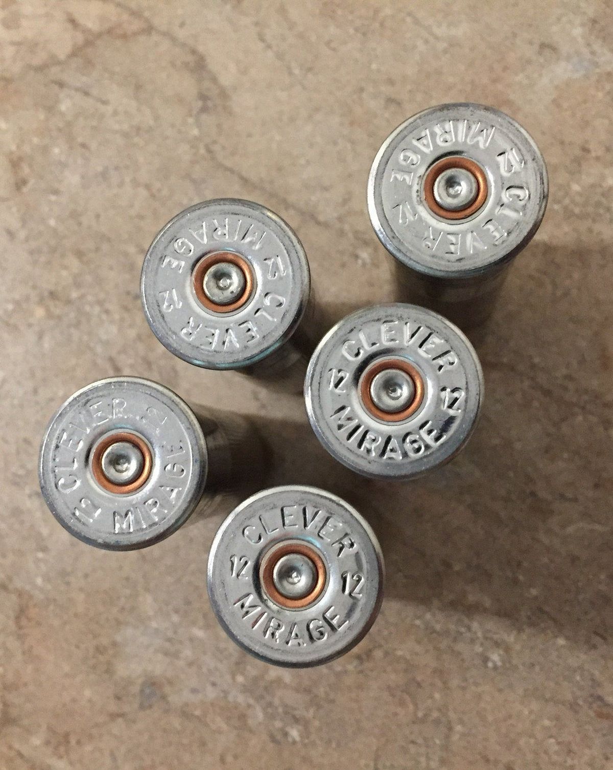 5 silver shotgun shell heads viewed from above embossed "Clever Mirage 12"