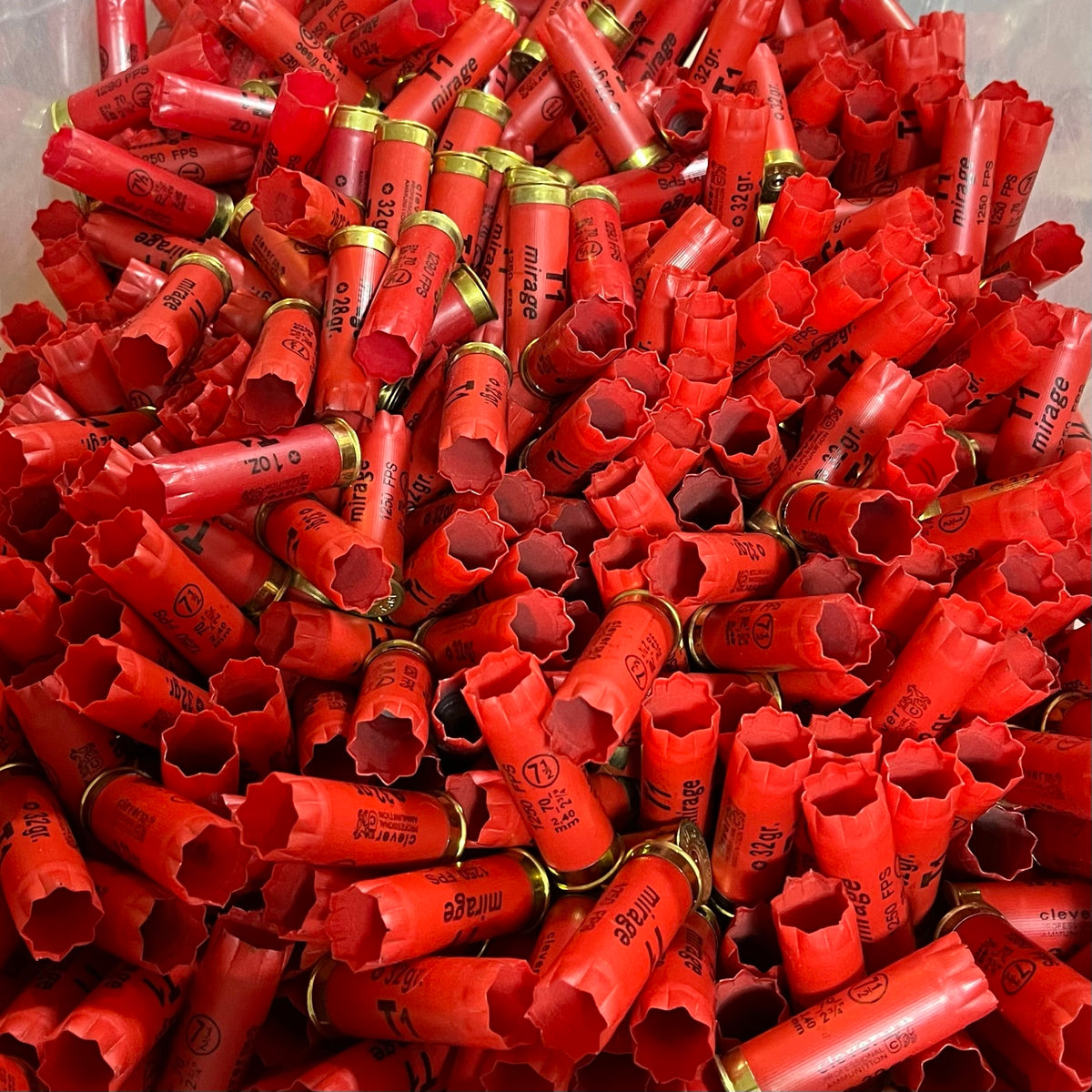 Large pile of red Clever Mirage 12 gauge shotgun shell hulls with gold bases