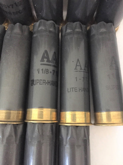 Close-up of four dark gray Winchester AA 12ga hulls standing upright, showing printed text like AA and SUPER-HANDICAP