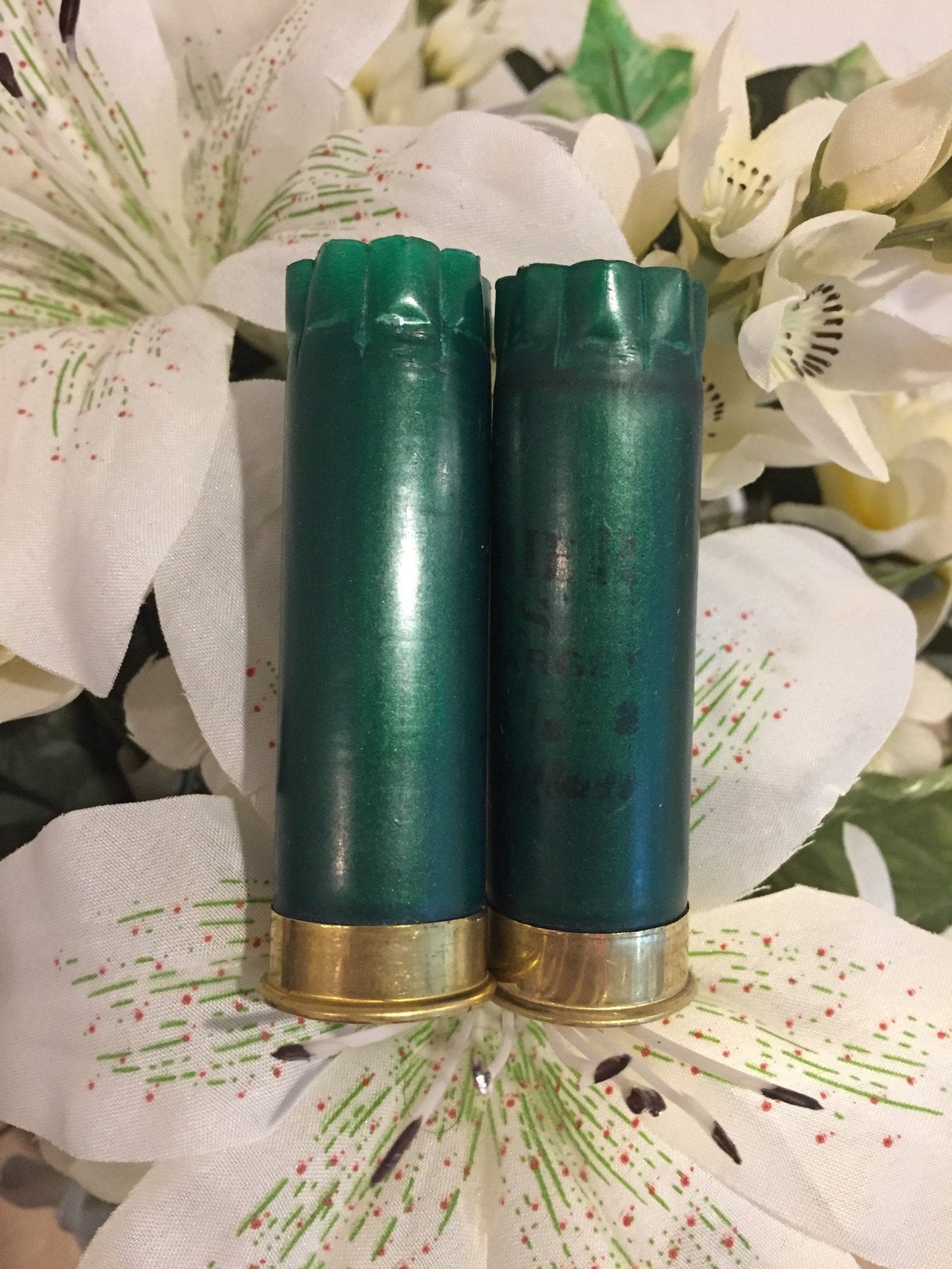Two Dark Green Shotgun Hulls Styled With Artificial Flowers
