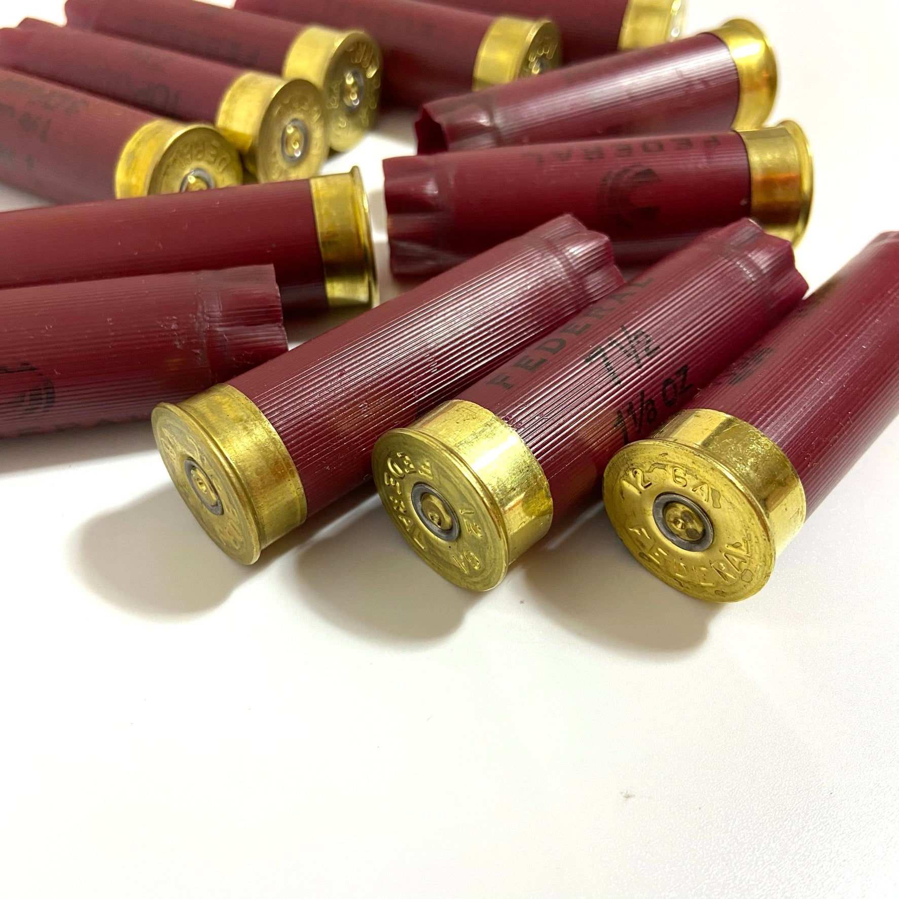 Close-up of dark red Federal 12 gauge shotgun shells featuring shiny brass bases.
