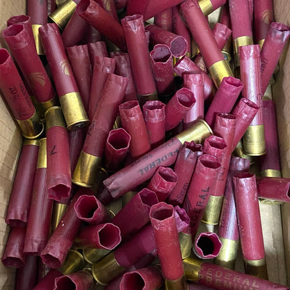 Large pile of dark red Federal 410 bore empty shotgun shells with gold high brass bases in a cardboard box