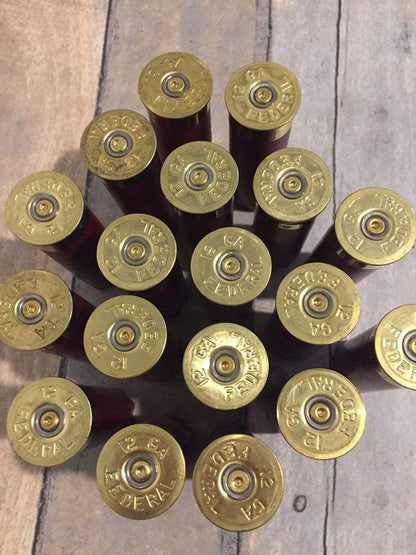 Close-up of dark red shotgun casings highlighting shiny gold bases and spent primers.