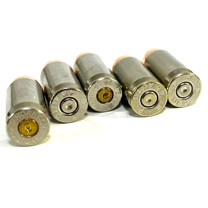 Five nickel 45 ACP dummy rounds for dry firing lying down to show the headstamps clearly.