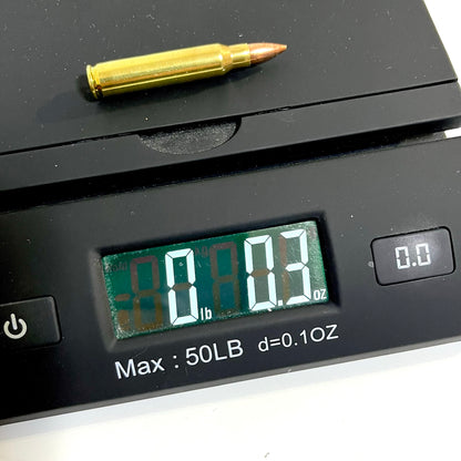 A single brass dummy cartridge placed on a digital scale, showing a weight reading of 0.3 oz.