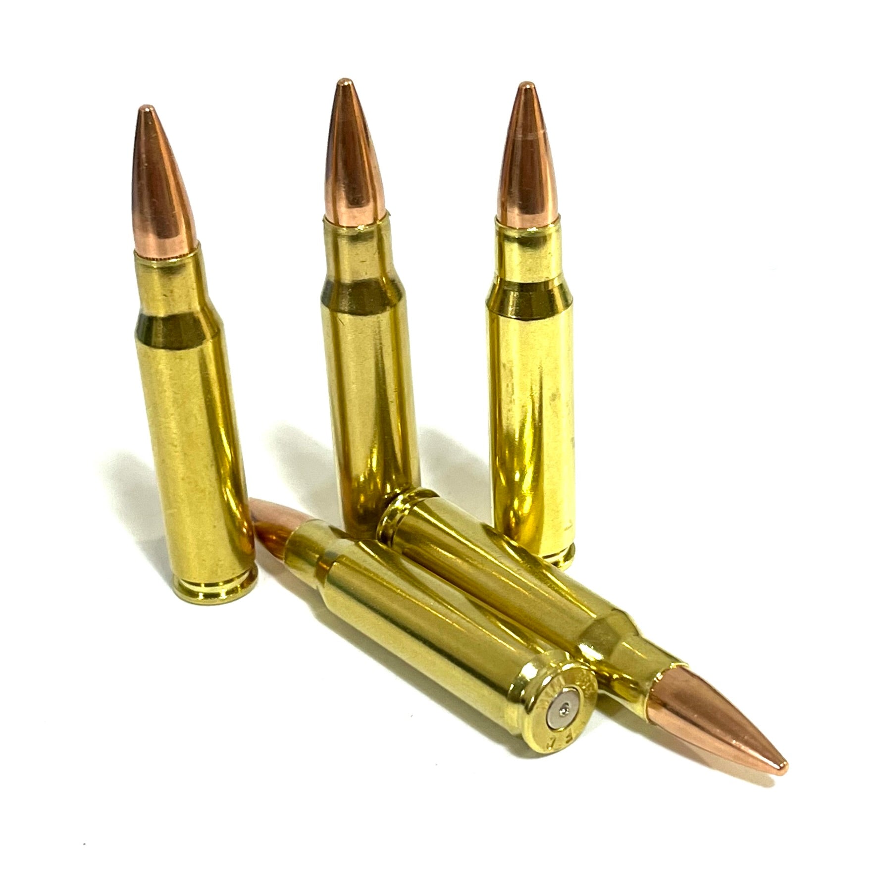 Five prop brass .308 dummy rounds, three upright and two lying flat with spent primer visible, white background