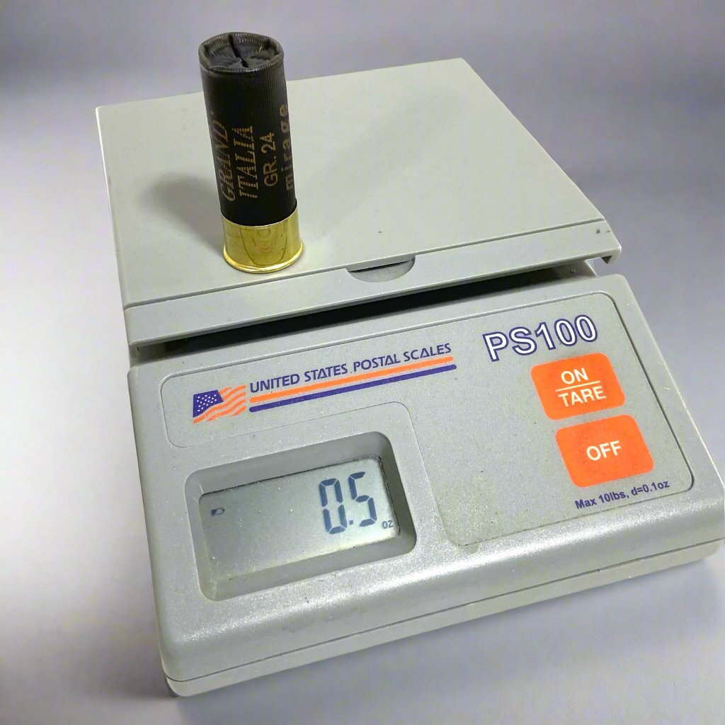 A single black shotgun shell standing upright on a digital scale displaying a weight of 0.5 ounces.
