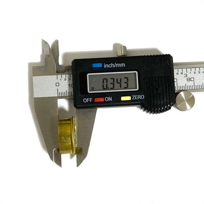 Digital caliper measuring wall thickness of an empty shotgun shell end cap with digital readout of 0.343 inches.