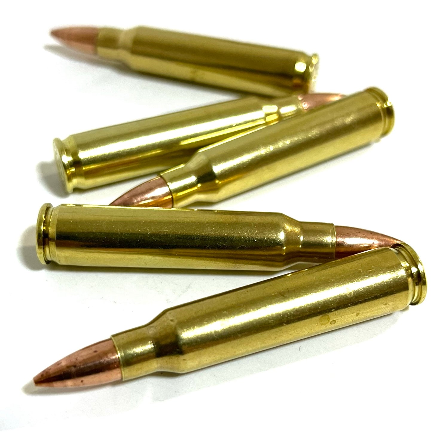 Five brass fake 223 rifle cartridges arranged horizontally in an alternating stacked layout against a white backdrop.