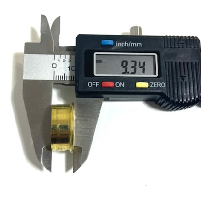 Digital caliper measuring the height of a gold brass 12 gauge shotgun shell headstamp bottom at 9.34 mm