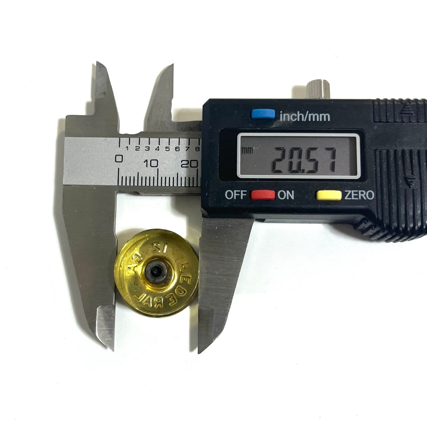 Digital caliper measuring the inner diameter of a gold brass 12 gauge Federal shotgun shell headstamp bottom at 20.57 mm