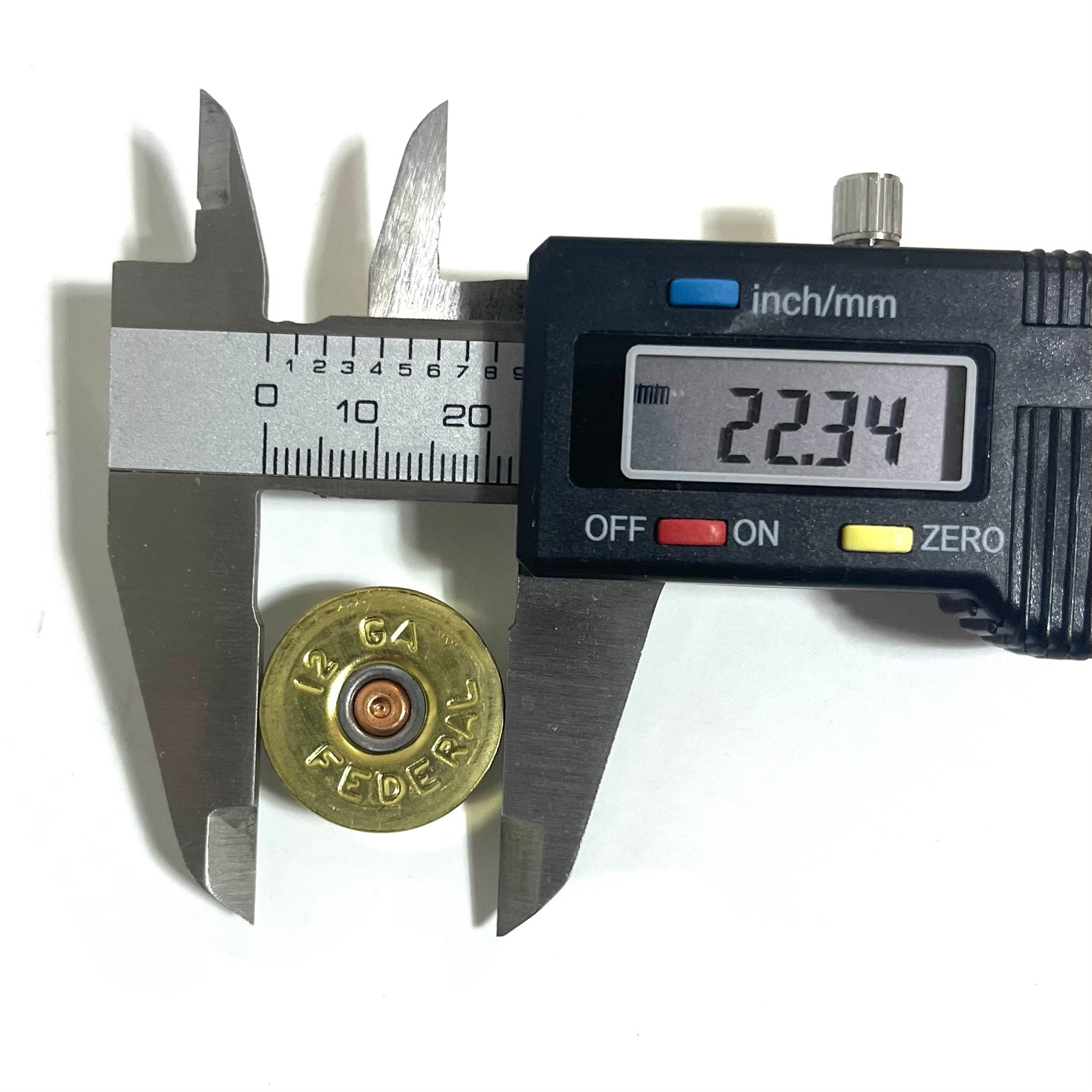 Digital caliper measuring the outer diameter of a gold brass 12 gauge Federal shotgun shell headstamp bottom at 22.34 mm