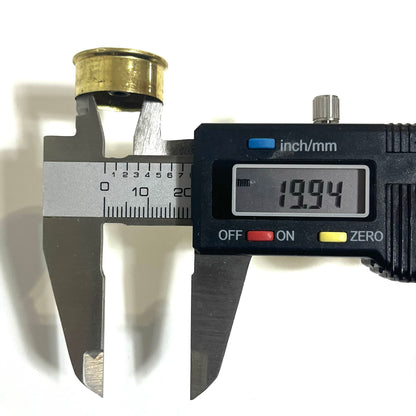 Digital caliper measuring the rim diameter of a gold brass 12 gauge shotgun shell headstamp bottom at 19.94 mm