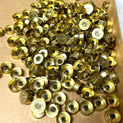 Large pile of gold brass 12 gauge Federal shotgun shell headstamp bottoms in a cardboard box