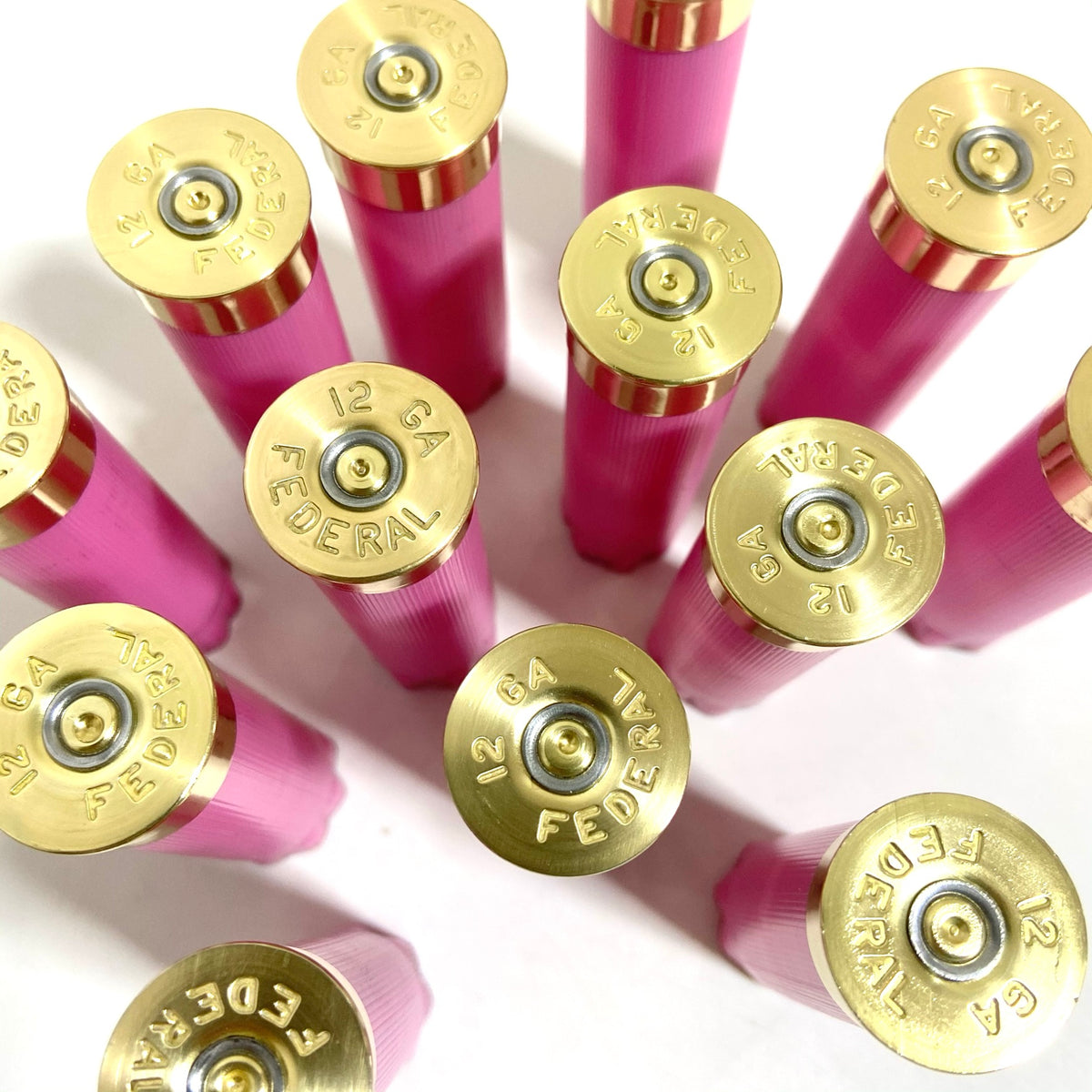 Several spent pink 12-gauge Federal shotshells fan outward, their brass headstamps reading '12 GA FEDERAL' clearly visible.