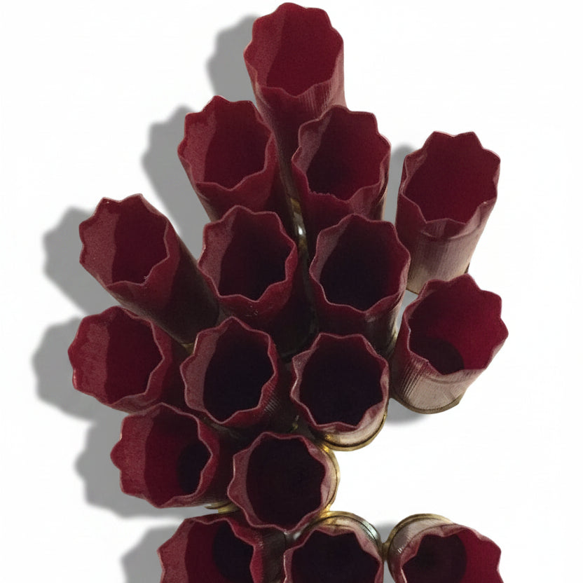 A cluster of empty dark red Federal twelve gauge spent cartridges upright showing open 8-star crimped ends.