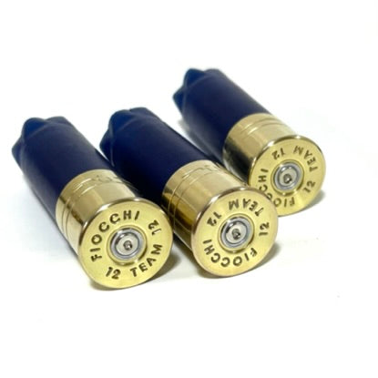 Three blue Fiocchi 12 gauge shotgun hulls on textured stone, showing gold high brass headstamps with readable Fiocchi text.