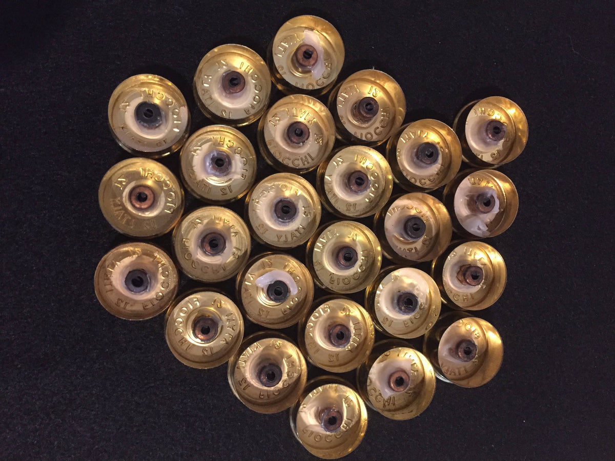 Gold brass headstamps with white residue inside, engraved with Fiocchi Italy 12 text, arranged in rows
