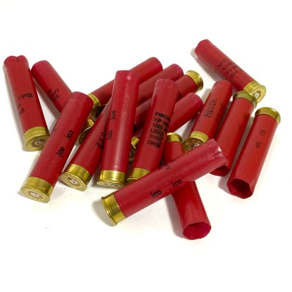 Loose pile of red Fiocchi 28 gauge shotgun shell hulls on a white background