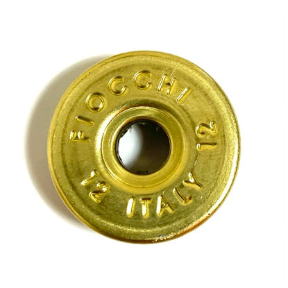 Close-up of a gold Fiocchi 12 gauge headstamp with primer removed and Italy markings.