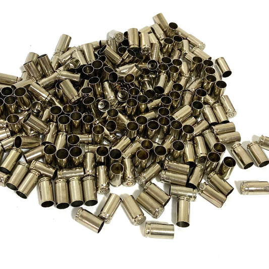 Large pile of shiny nickel 9mm empty casings covering a white background